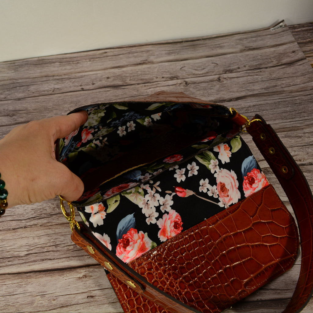 Cognac croc-print leather shoulder bag open showing floral lining