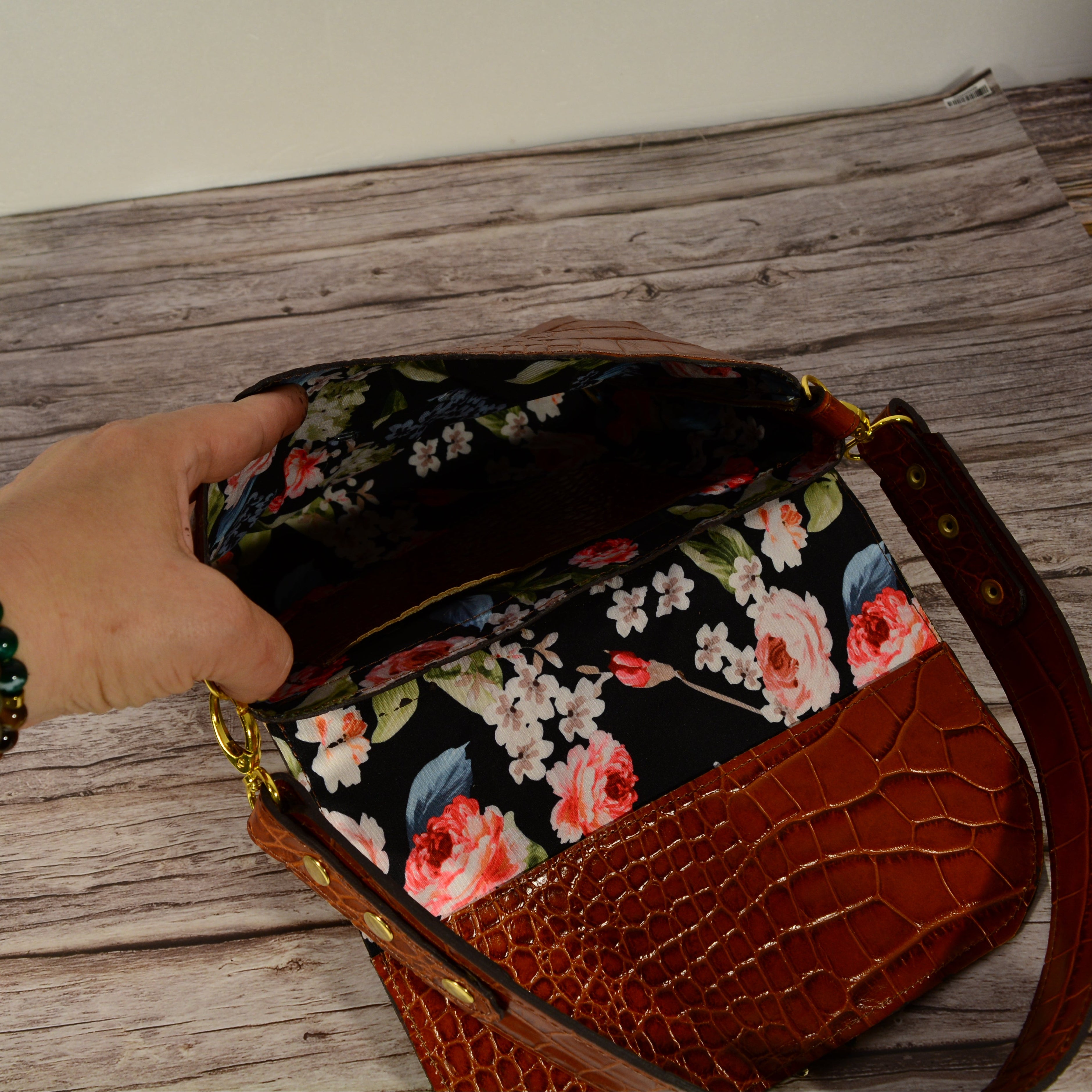 Cognac croc-print leather shoulder bag open showing floral lining
