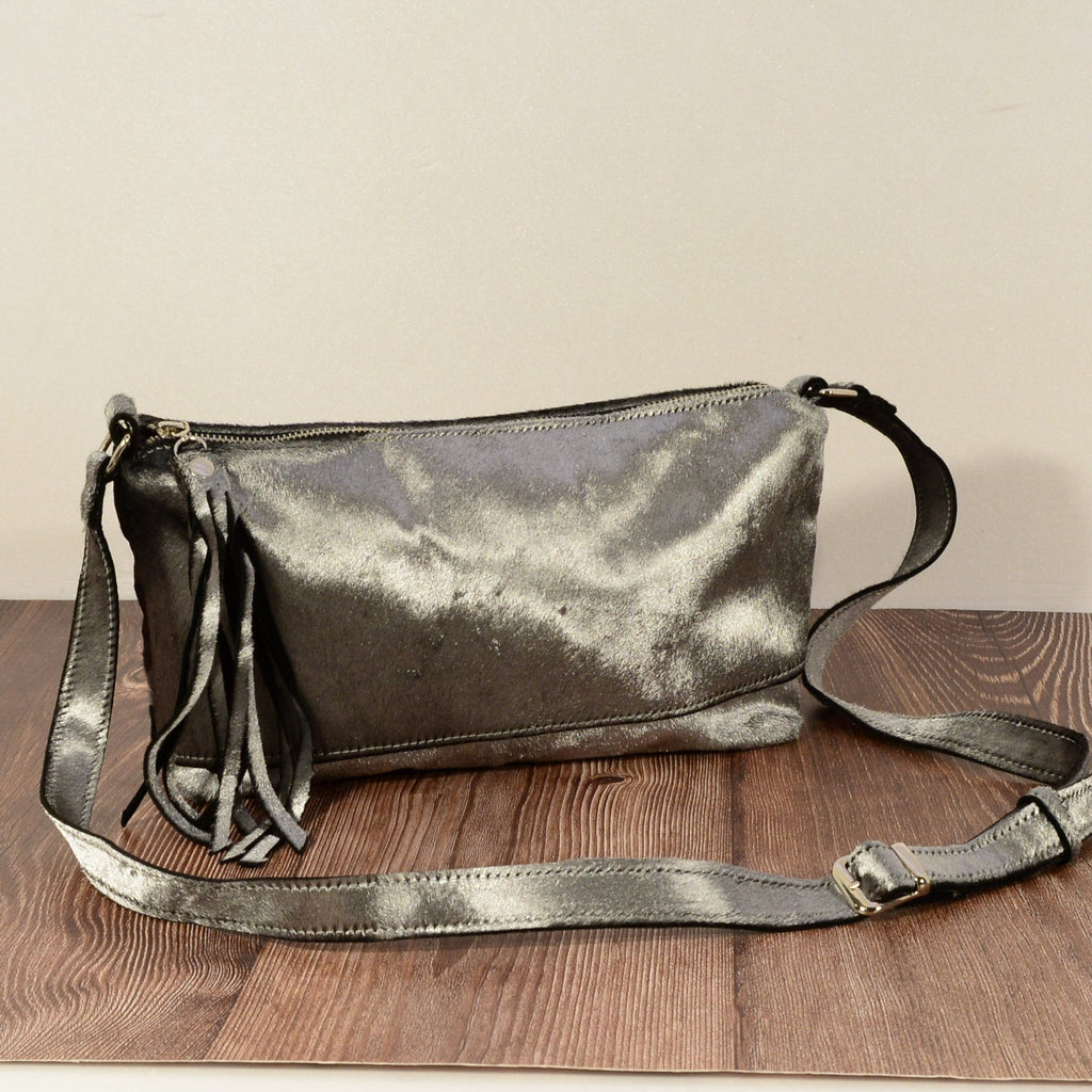 Silver grey fur crossbody bag on wooden surface with adjustable strap
