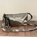 Silver grey fur crossbody bag on wooden surface with adjustable strap