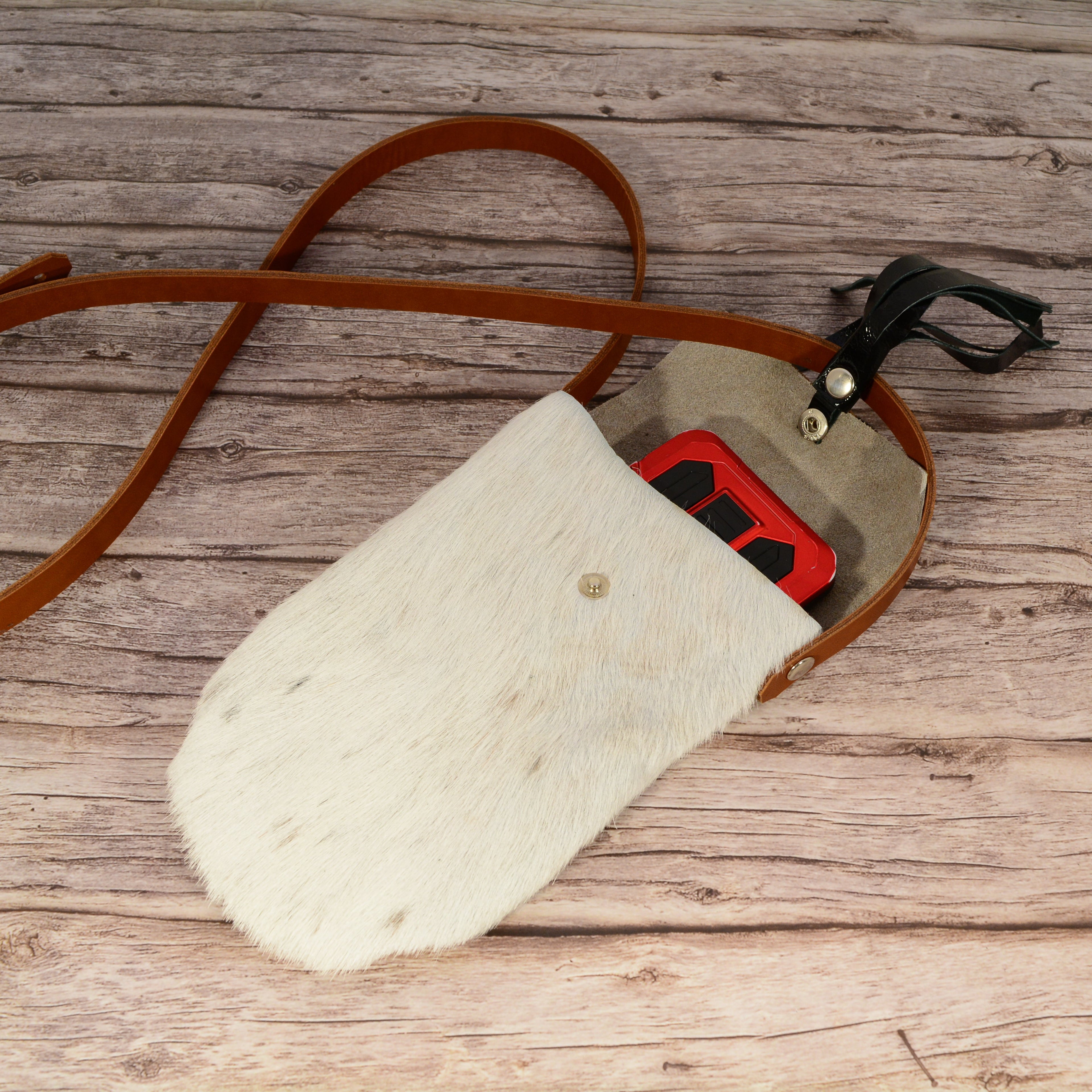 Fur phone bag open showing grey suede lining with smartphone inside